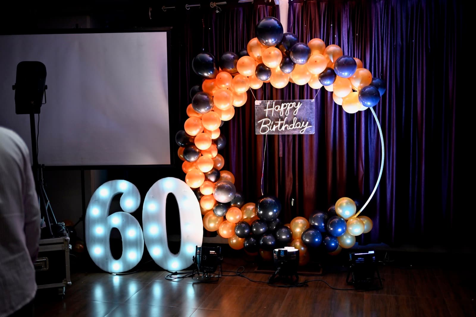 60th birthday hoop décor with marquee numbers and Happy Birthday neon