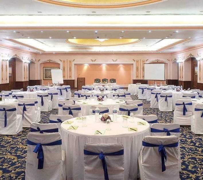 Formal indoor hall with round tables and navy chair sashes